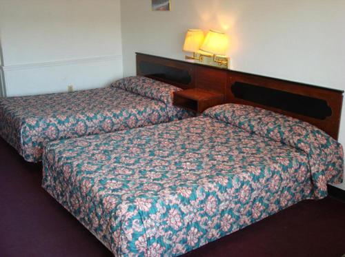 una habitación de hotel con 2 camas en una habitación en Gray Plaza Motel, en Benton