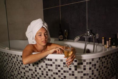 Eine Frau in einer Badewanne mit einem Glas Wein. in der Unterkunft Kateryna in Poljana