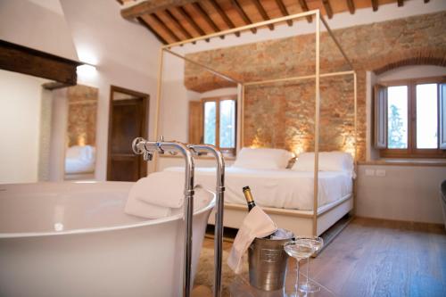 ein Badezimmer mit einer Badewanne und ein Schlafzimmer mit einem Bett in der Unterkunft Villa Barberino in Meleto