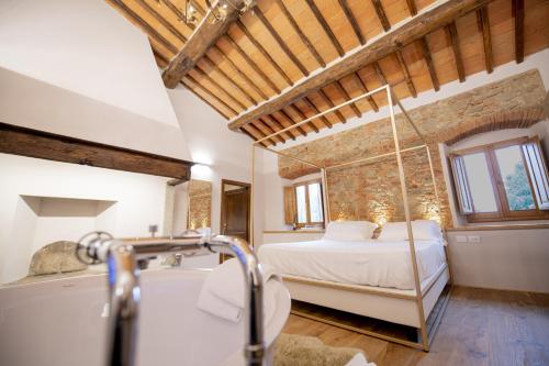 a bedroom with a bed and a tub in a room at Villa Barberino in Meleto