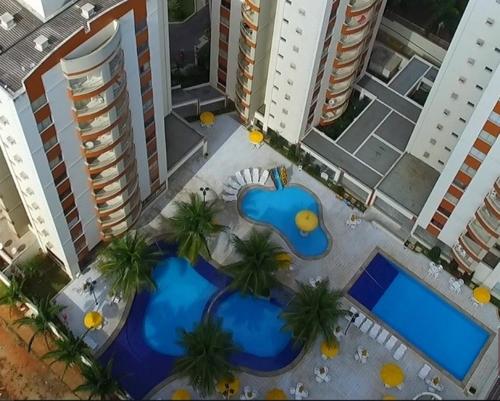 an overhead view of two pools with palm trees and buildings at Recanto do Bosque Caldas Novas Temporada in Caldas Novas