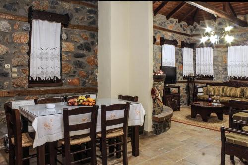 a dining room with a table and a living room at Nemesis Suites in Palaios Agios Athanasios