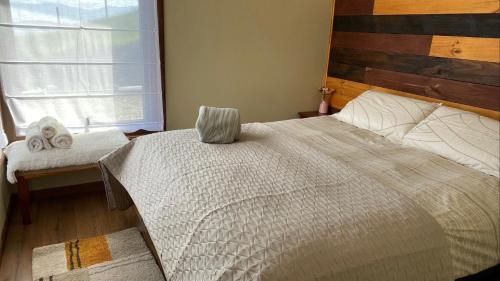 ein Schlafzimmer mit einem großen Bett und einem Fenster in der Unterkunft Cabañas Las Terrazas De Iculpe in Lago Ranco