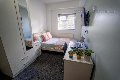 a small room with a bed and a mirror at Lovely homely studio available in Birmingham