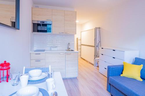 un salon avec un canapé bleu et une cuisine dans l'établissement Forclaz River 1- Beautifully crafted Studio, à Chamonix-Mont-Blanc