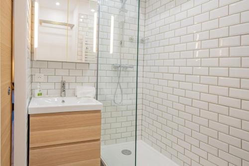 une salle de bain avec un lavabo et une douche en verre dans l'établissement Forclaz River 1- Beautifully crafted Studio, à Chamonix-Mont-Blanc