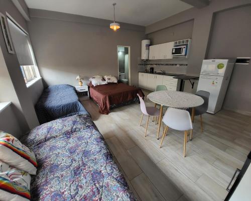 Habitación con cama, mesa y cocina. en Hermoso monoambiente p/4 personas en el centro de Salta en Salta