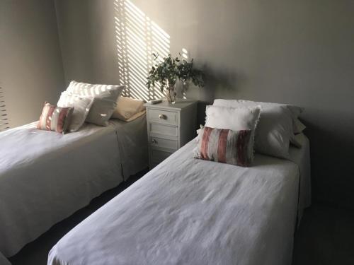 una camera con 2 letti con cuscini e cassettiera di Casa grande barrio Rumenco a Mar del Plata