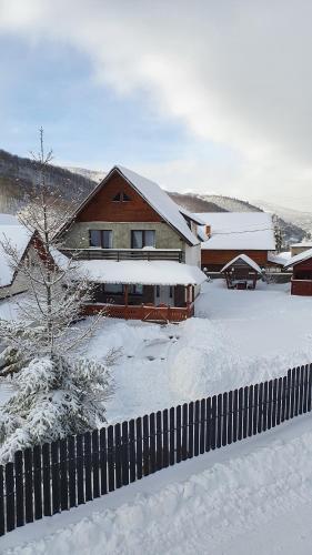 une maison dans une cour recouverte de neige dans l'établissement Cabana Rustic, à Cavnic