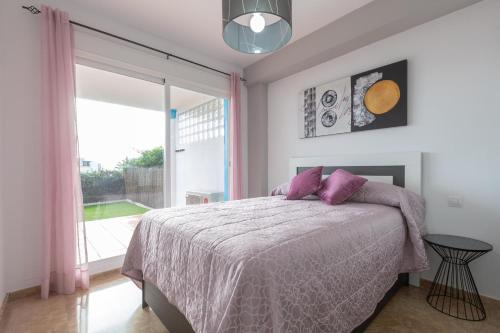 ein Schlafzimmer mit einem Bett und einem großen Fenster in der Unterkunft Casa Carmen in Estepona