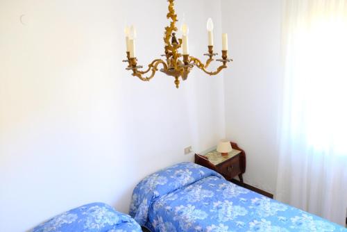 a bedroom with a bed and a chandelier at Hotel Il Canneto in Porto Ceresio