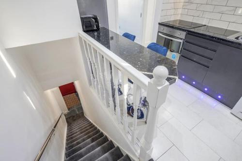 a staircase in a kitchen with a person standing on it at TMS Top Flat! Tilbury! in Tilbury