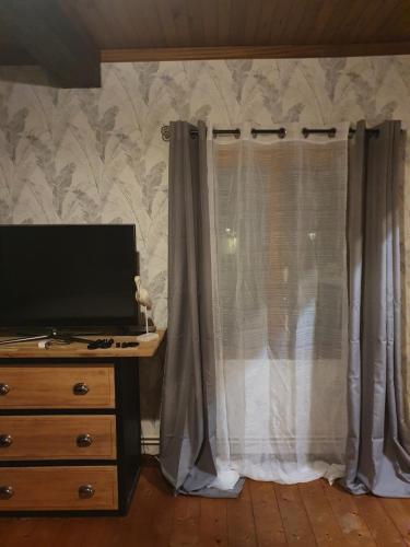 1 dormitorio con vestidor y ventana con cortinas en Chambre d'hôtes Le Relais de Belloy en Belloy sur Somme
