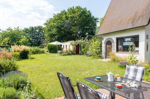 a patio with a table and chairs in a yard at Familienhaus Sonne in Mukran