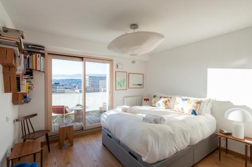 une chambre avec un grand lit et une grande fenêtre dans l'établissement Sky Avenue - Magnifique T2 avec vue époustouflante, à Lyon