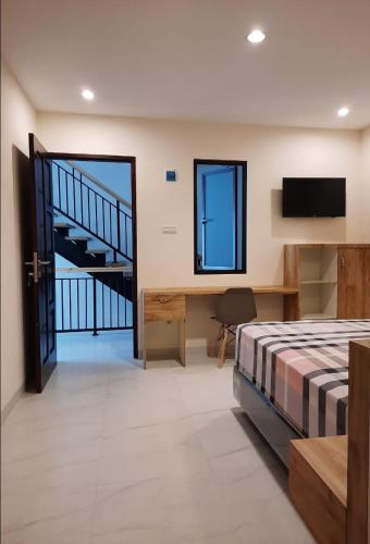 een slaapkamer met een bed, een bureau en een trap bij Lauwrens Guest House in Makassar