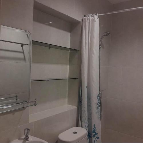 een badkamer met een douche, een toilet en een wastafel bij Lauwrens Guest House in Makassar