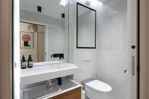 une salle de bain avec un lavabo, des toilettes et un miroir dans l'établissement Sky Avenue - Magnifique T2 avec vue époustouflante, à Lyon