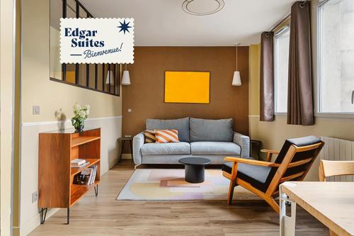 uma sala de estar com um sofá e uma mesa em Edgar Suites Expo Paris Porte de Versailles em Paris