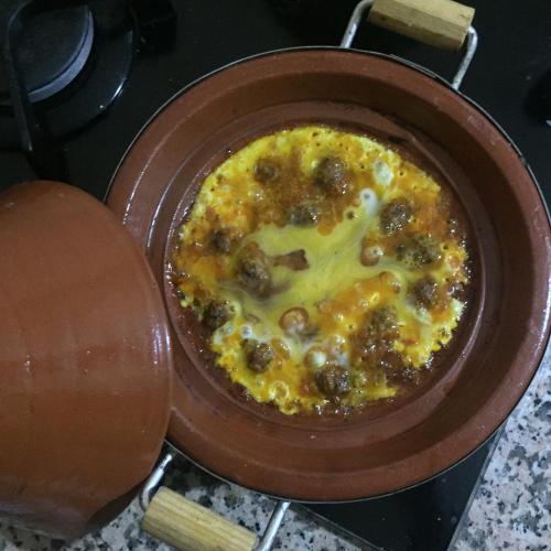 a pot of food with mushrooms and cheese on a stove at Riad ait Ben Haddou in Aït Ben Haddou