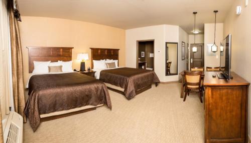 um quarto de hotel com duas camas e uma secretária em Teddy's Residential Suites New Town em New Town