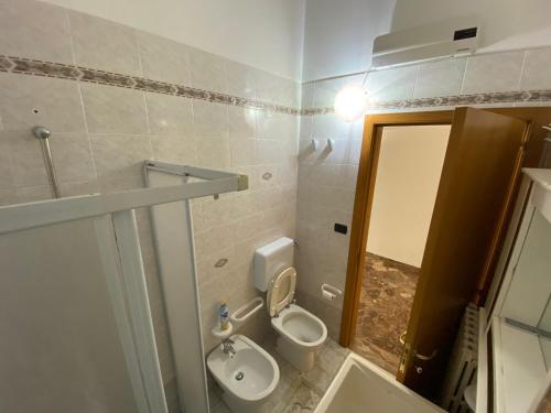 ein Badezimmer mit einem WC, einem Waschbecken und einem Spiegel in der Unterkunft Casa Da Simone in Melissano
