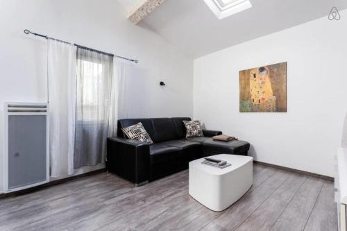- un salon avec un canapé noir et une table basse dans l'établissement T2 Saint-Anne - Air Rental, à Montpellier