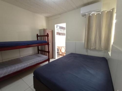 a bedroom with two bunk beds and a window at Kitnets Recanto Caiobá in Matinhos