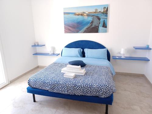 - une chambre avec un lit bleu et des serviettes dans l'établissement La casa del Gabbo apartment, à Monopoli