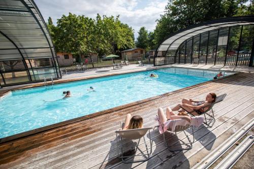 a group of people sitting in chairs in a swimming pool at Huttopia Les Châteaux in Bracieux
