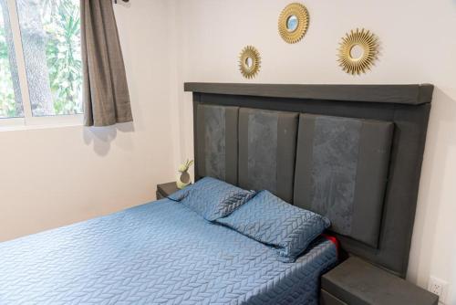 1 dormitorio con 1 cama con sábanas azules y 2 espejos en Elvis, en Ciudad de México