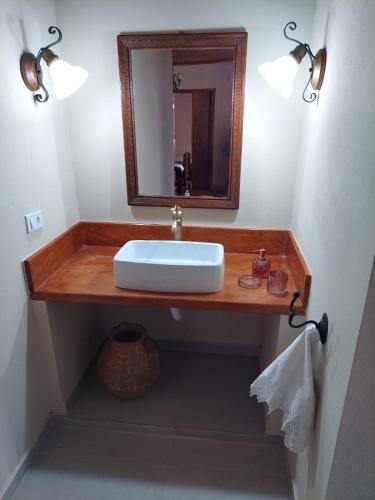 a bathroom with a sink and a mirror at Solar dos Tios in São Thomé das Letras