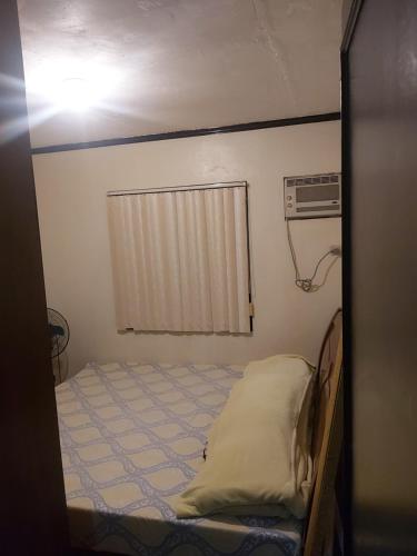 - une petite chambre avec un lit et une fenêtre dans l'établissement RoomForRent, à Balibago