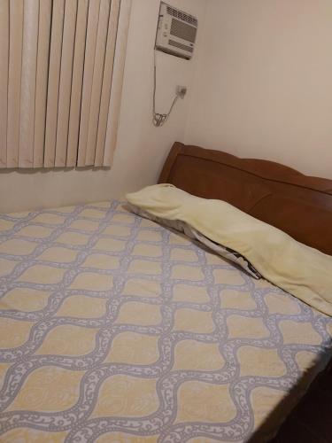 Un dormitorio con una cama con una manta. en RoomForRent en Balibago