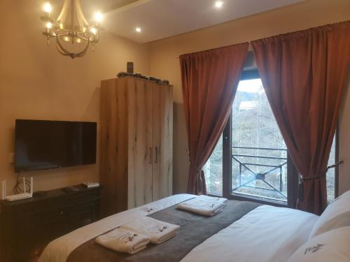 a bedroom with a bed and a window with towels at Golden Mountain A75 NLux Milmari in Kopaonik