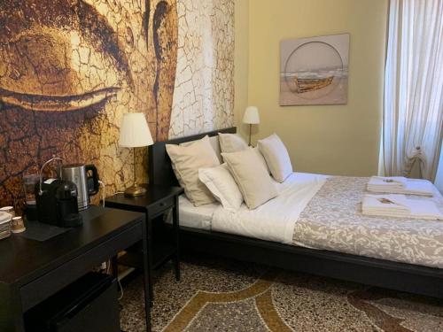 a bedroom with a bed and a desk and a painting at Domus La Foce Hotel self check in in Genova