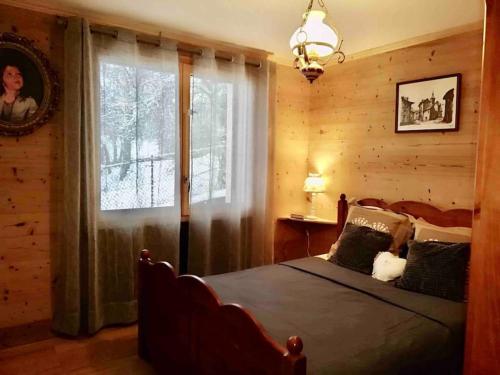 Un dormitorio con una cama grande y una ventana en Chalet des Fées , 2 chambre ,70m2 ,navette gratuite,, en Les Avanchers