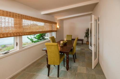 a dining room with a wooden table and yellow chairs at Dream Scape in Fort Bragg