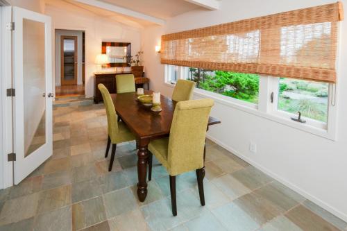 a dining room with a wooden table and yellow chairs at Dream Scape in Fort Bragg