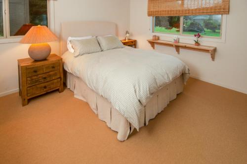 a bedroom with a bed and a lamp on a night stand at Dream Scape in Fort Bragg