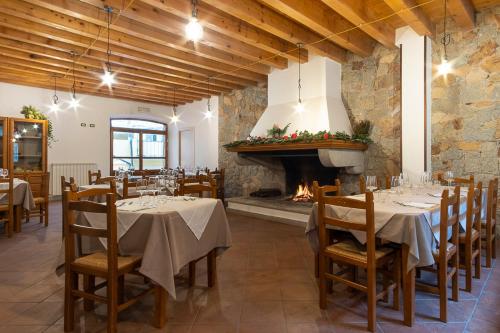 uma sala de jantar com mesas e uma lareira em Locanda Sighimi em Lanusei