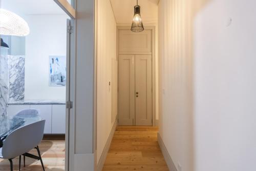 a hallway with a door and a table and a chair at FLH Downtown Marble Apartment in Lisbon