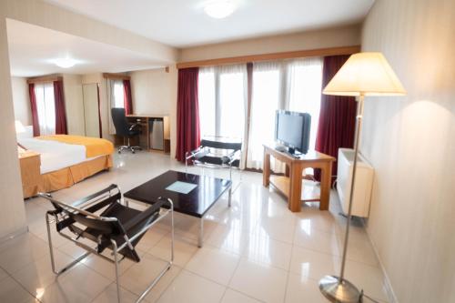a hotel room with a bed and a living room at El Prado in Neuquén