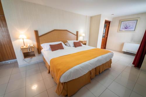 a bedroom with a large bed in a hotel room at El Prado in Neuquén