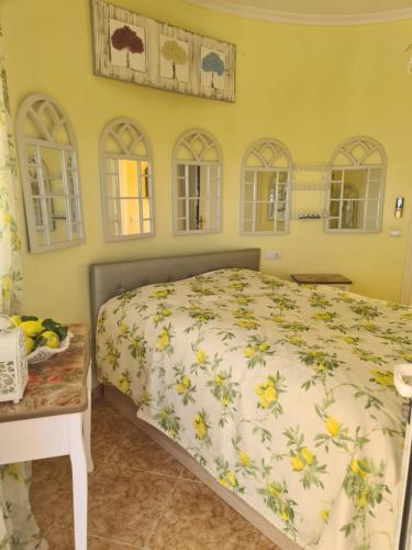 Schlafzimmer mit einem Bett, einem Tisch und Fenstern in der Unterkunft Château Angélique in Valencia