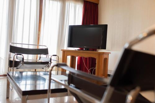 a living room with a tv and two chairs at El Prado in Neuquén