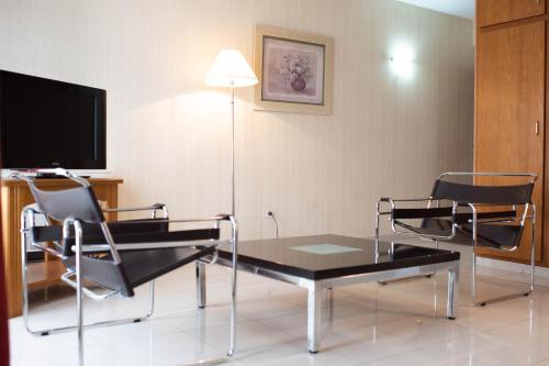 a living room with a table and chairs and a tv at El Prado in Neuquén