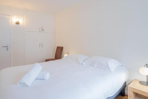 une chambre avec un lit blanc avec des oreillers blancs dans l'établissement Portes du Brevent -1 bedroom apartment with magnificient Mont Blanc views, à Chamonix-Mont-Blanc