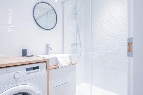 La salle de bains est pourvue d'un lave-linge et d'une douche. dans l'établissement Portes du Brevent -1 bedroom apartment with magnificient Mont Blanc views, à Chamonix-Mont-Blanc