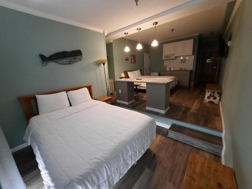 a bedroom with a white bed and a table at Palm Suites in Atlantic Beach
